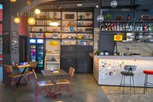 雅典Athens Hub Hostel的一间带桌椅和柜台的餐厅