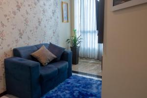 费拉迪圣安娜Apart vitória的客厅配有蓝色椅子和蓝色地毯