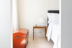 赫尔辛基Stylish new 1br apt in Aurinkolahti的一间卧室配有一张床和一张带台灯的桌子