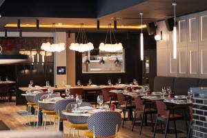约克Malmaison York的用餐室配有桌椅和灯光