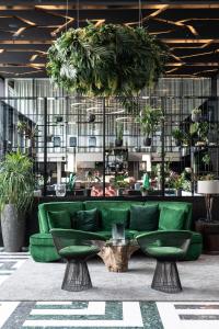 哥本哈根斯哥特皮特酒店的绿沙发,在种植盆栽植物的房间里
