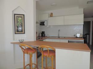 阿德耶Apartment-Hotel Altamira的厨房配有2把椅子和木制台面
