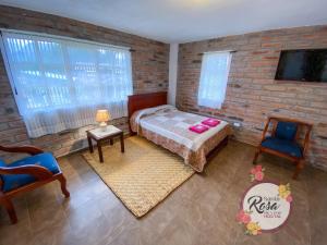Hacienda ZuletaSanta Rosa de Lima Hostal Zuleta的一间卧室设有一张床和砖墙