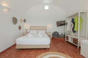 锡拉夏岛Petinos traditional house的卧室配有白色的床,铺有瓷砖地板。
