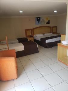 帕图斯迪米纳斯Gran Roza Hotel的酒店客房,设有两张床和一张沙发