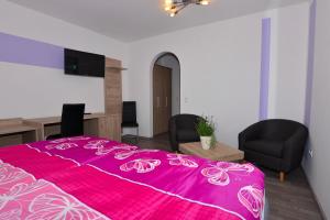 MehlmeiselDas Arni´s的一间卧室配有粉红色的床、两把椅子和一张书桌