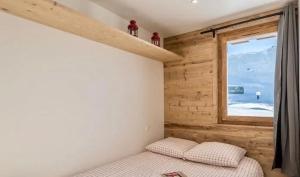 葱仁谷Apartment ski in/out Val Thorens的一间卧室设有一张床和一个美景窗户。