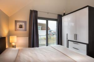 海利根港Ostsee - Appartement Nr 63 "Möwennest" im Strand Resort的一间卧室设有一张床和一个大窗户