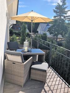 奥茨塞巴德·迪尔哈根"GESTRANDET" in der Villa Katharina-的阳台配有带遮阳伞的天井桌椅