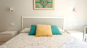 塞维利亚Sevilla Alameda PG Apartamentos的一间卧室配有蓝色和黄色枕头的床