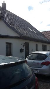 卡尔斯哈根ferienwohnung köster的两辆汽车停在房子前面