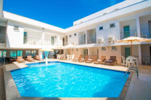 塞古罗港索贝拉诺雷得香格里拉酒店的一座带椅子和遮阳伞的游泳池位于一座建筑旁边