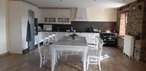 CalabreoCasa Souto Robledo的厨房配有白色的桌子和白色的椅子