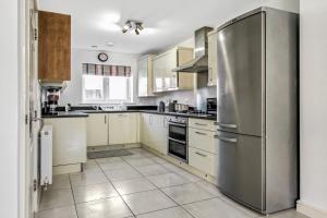 德比Emerald En-suite in Derby的厨房配有不锈钢冰箱和白色橱柜