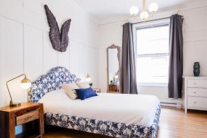 蒙特利尔MTLVacationRentals -The Chic Laurier的卧室配有蓝色和白色的床和窗户。