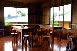 蒙泰韦尔德哥斯达黎加Casitas de Montaña Cabuya的餐厅设有木桌、椅子和窗户。