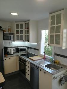卡萨雷斯Penthouse的厨房配有白色橱柜和水槽