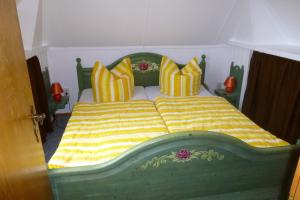 坡瑟利特兹Heublein的一间卧室配有绿色和黄色的床和枕头