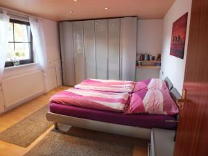 弗里茨拉尔Ferienwohnung Iris的一间卧室配有一张粉色和白色床单。