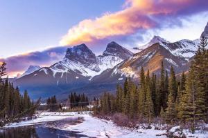 坎莫尔Banff Gate vacation townhouse的白雪 ⁇ 的山脉,有河流和树木