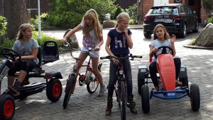 BomlitzGästehaus Bommelsen - FEWO 1的一群儿童骑着自行车和汽车