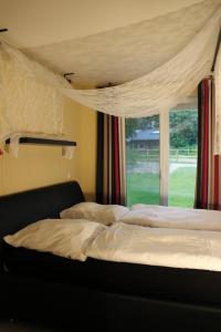FriedenstalKamaahr的一间卧室配有床和带窗帘的窗户