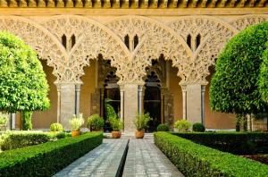 萨拉戈萨apartamento centro historico Zaragoza的华丽的建筑,带有种有灌木和树木的庭院