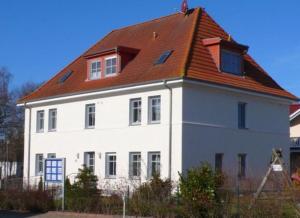 奥斯特巴德里克Ferienwohnung "Uferschwalbe"的一座大型白色房屋,设有红色屋顶