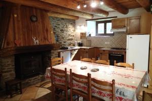 卢登维耶尔artiguelongue grange restaurée的厨房配有桌子、冰箱和壁炉。