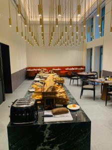 布达佩斯Kozmo Hotel Suites & Spa - The Leading Hotels of the World的餐厅里一张长桌,上面有食物