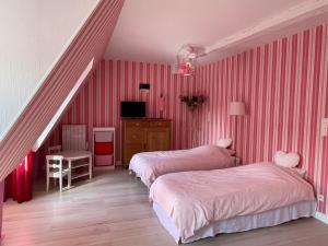 Vernou-sur-BrenneLa Métairie的一间卧室设有两张床,楼梯有粉红色条纹