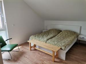 贝尔恩卡斯特尔-库斯Sonnenufer Apartment & Moselwein I的卧室配有1张床、1张桌子和1把椅子