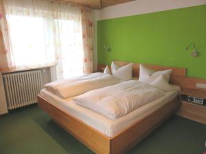 福森Ferienhaus Weiß, Sandra Weiß的一间卧室设有一张大床和绿色的墙壁