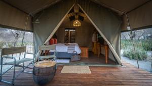 马翁Boteti Tented Safari Lodge的帐篷配有一张床和椅子