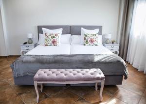 LiañoHotel Peñas Blancas的一间卧室配有一张大床和粉红色长凳