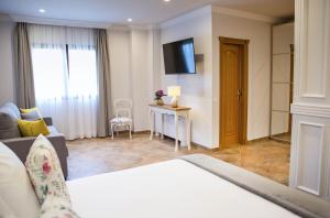 LiañoHotel Peñas Blancas的酒店客房配有床、沙发和电视。