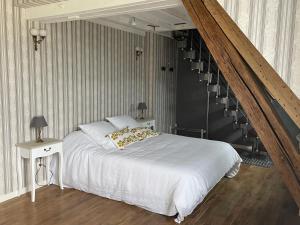 Vernou-sur-BrenneLa Métairie的卧室配有白色的床和楼梯。