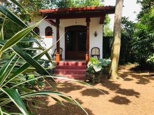 本托塔Swarnapaya résidence的前面有红色楼梯的小白色房子