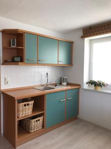 克林根塔尔Am Dürrenbachtal的厨房配有蓝色橱柜和水槽