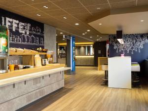 布尔昆Ibis Budget Bourgoin Jallieu Centre的一间设有柜台和酒吧的快餐店