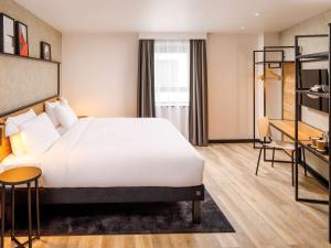 萨顿ibis London Sutton Point的酒店客房设有一张大床和一张书桌。