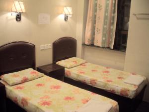 香港C U Again Hostel的鲜花客房内的两张单人床