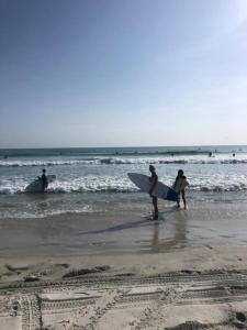 代托纳海滩湾海滨汽车旅馆的一群人在海滩上漫步,并有冲浪板