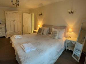 Orchard Cottage的卧室配有白色的床和2条毛巾