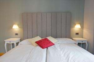 MiazzinaHotel Milano & Apartments的一张带两个枕头的白色床和两个灯