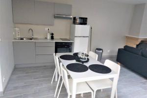 弗朗斯地区特朗布莱Charmante maison cosy T2 avec terrasse的一间厨房,里面配有白色的桌子和椅子