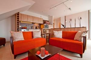 奥斯特巴特宁哈根ostseeLOGGIA的客厅配有2张橙色沙发和1张桌子