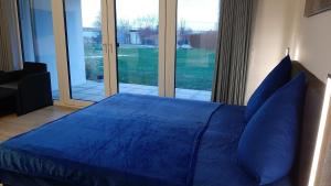 阿尔特费尔Apartment 10 in Altefähr am Strelasund的一间卧室设有一张蓝色的床和大窗户