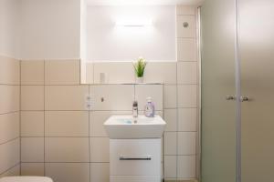 泰尔托Gästezimmer Teltow的白色的浴室设有水槽和淋浴。