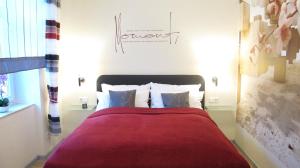 岑平Ferienwohnungen Villa Waldblick的一间卧室配有一张带红色毯子和枕头的床。